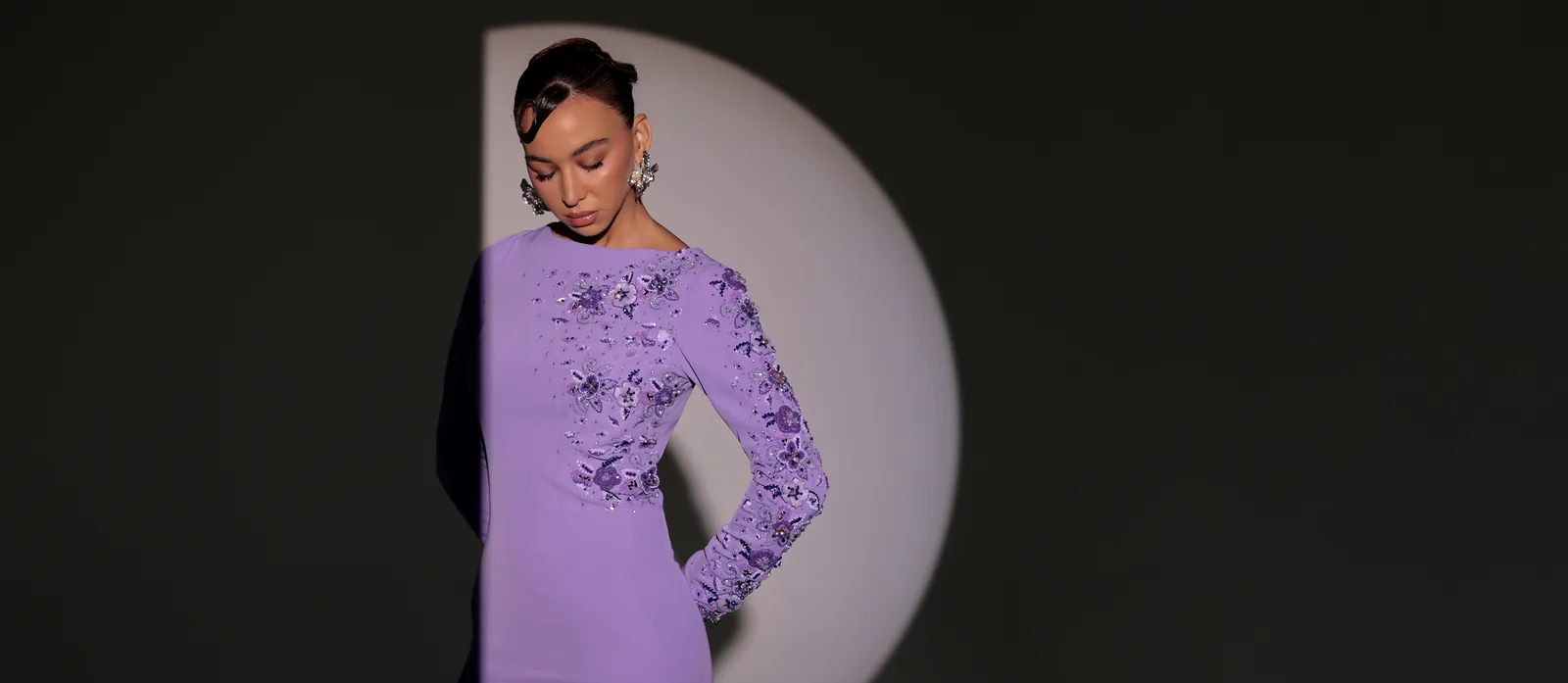 Li Luce campaign model wearing an embellished lilac dress in sculptural studio lighting