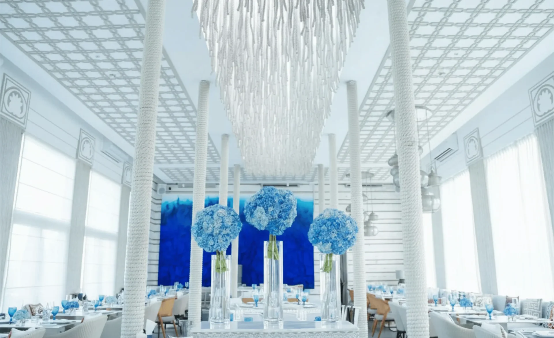 White floral arrangements and blue details at an outdoor celebration