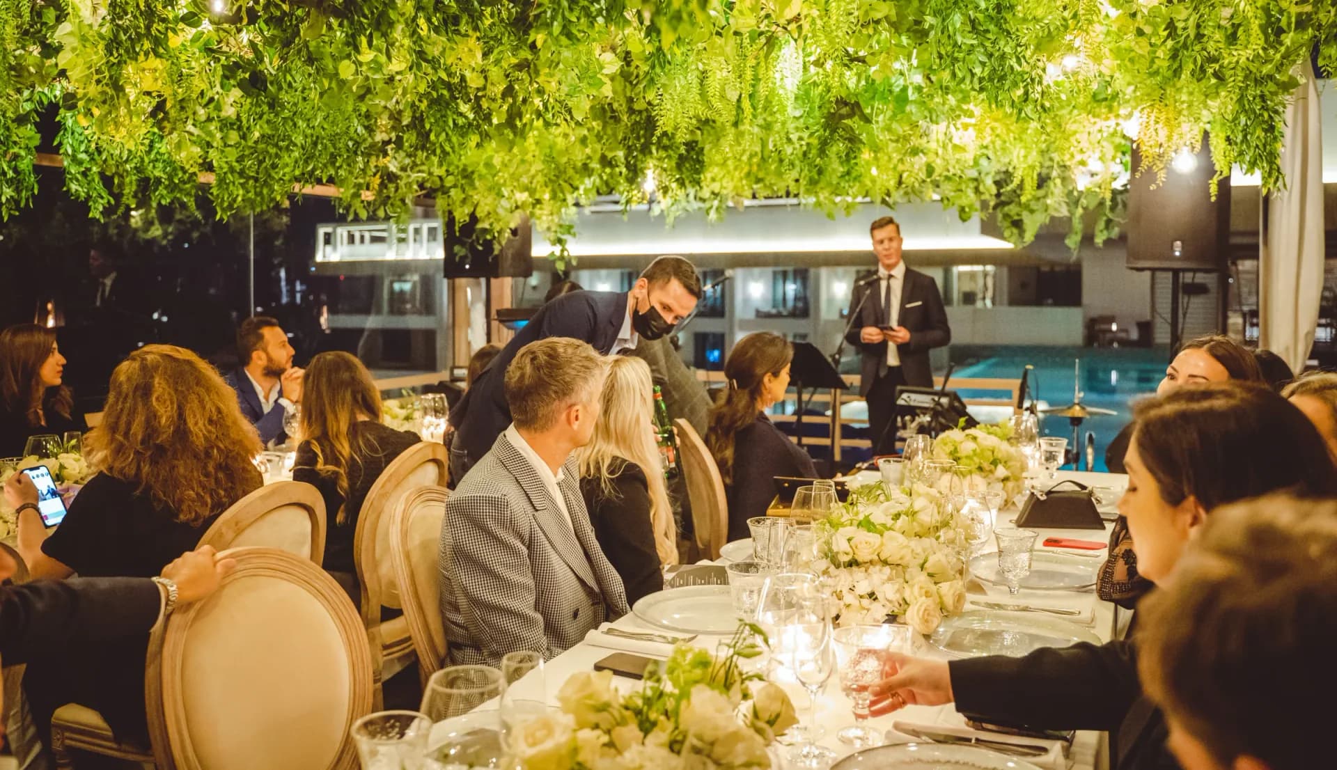 Guests gathered around a long table in a garden setting
