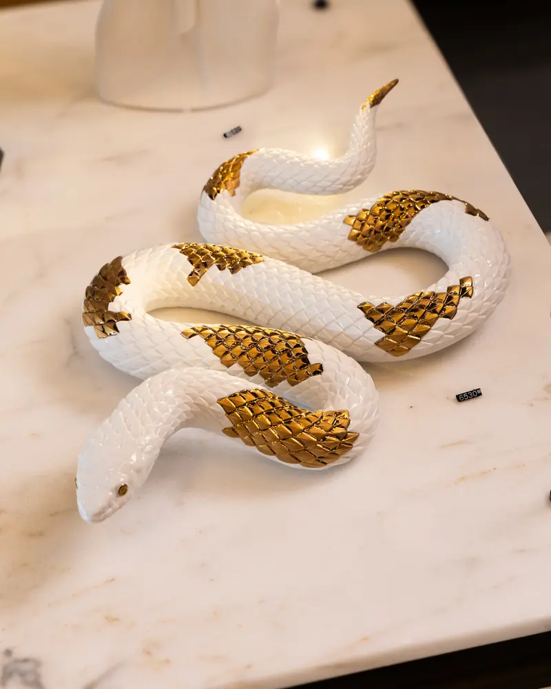 Cities store: a white and gold porcelain snake on marble