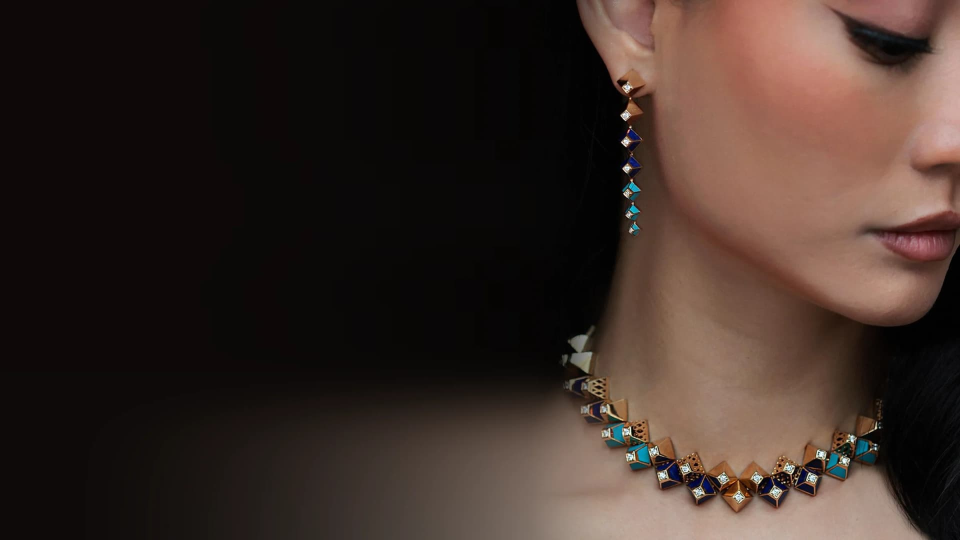 Dina J Jewelry campaign: a model in profile wearing a long lapis and turquoise drop earring and the matching necklace