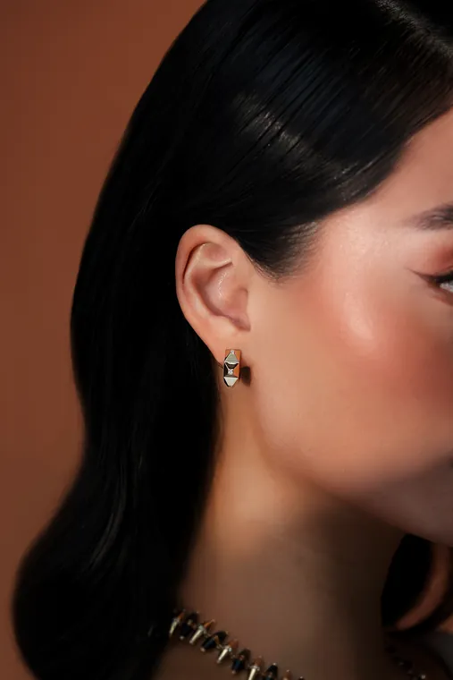 Dina J Jewelry campaign: a gold earring in profile