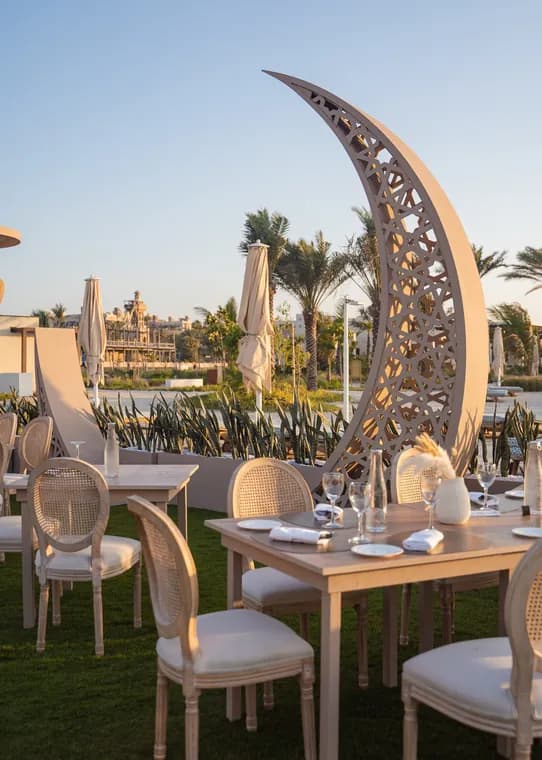 Moements Ramadan dinner set beneath a carved crescent moon