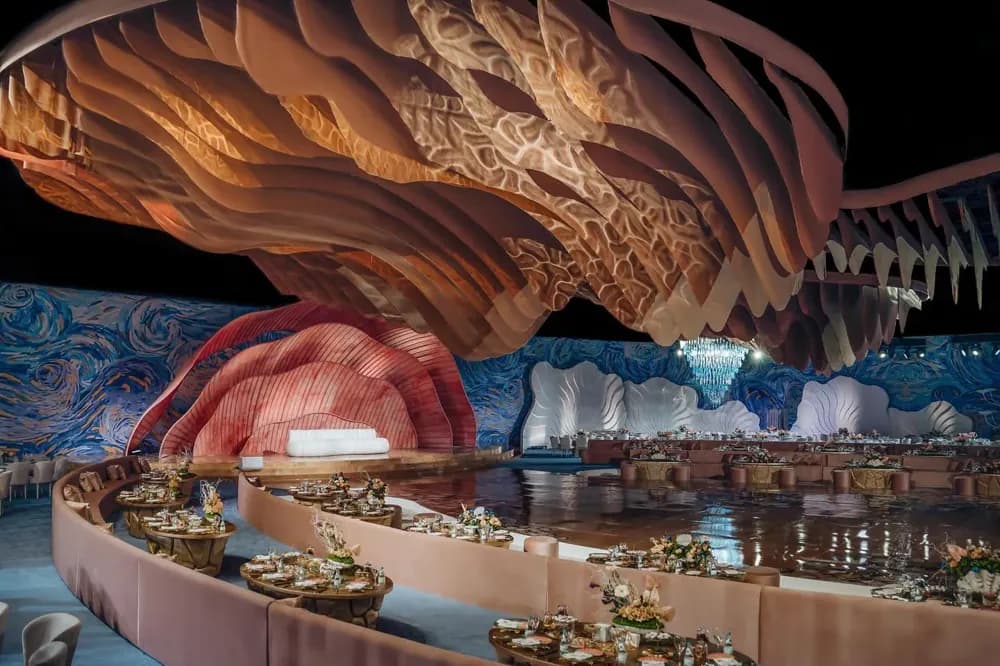 Moements wedding venue: sculpted shell canopies over a curved table layout and a mirrored floor