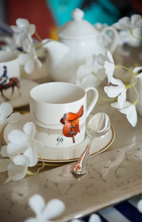 Vitelli Equestrian cup and saucer painted with a leather saddle, among white blossoms