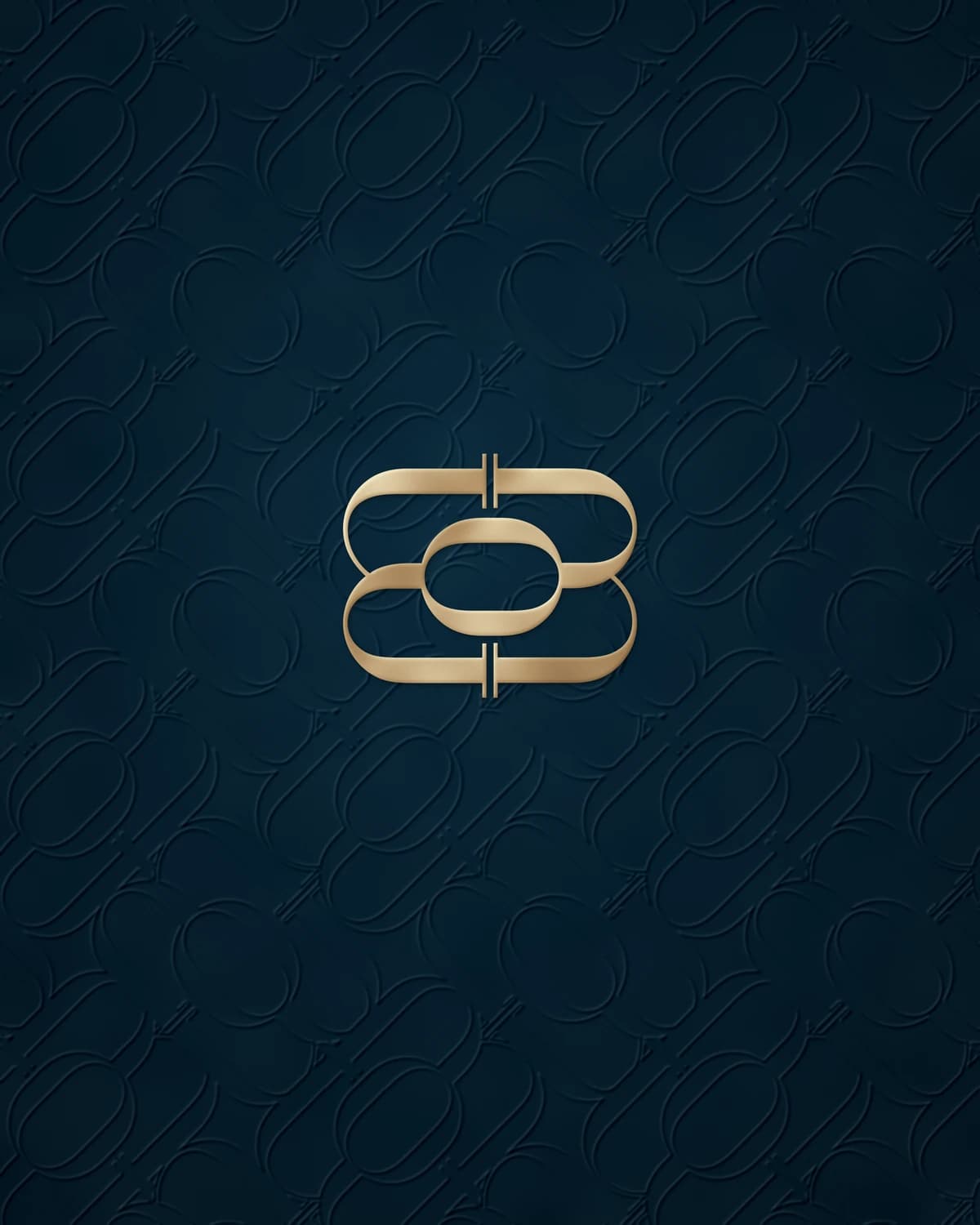 Moements emblem in gold foil on navy paper embossed with the brand pattern